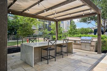 A patio with a table and chairs under a canopy.